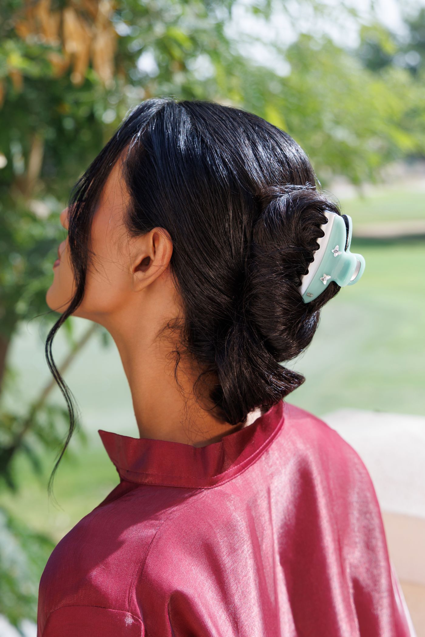 Mint claw clip in dark hair, in profile